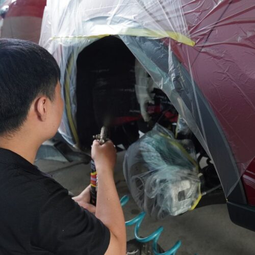 Kỹ thuật viên xịt phủ lên bề mặt gầm xe